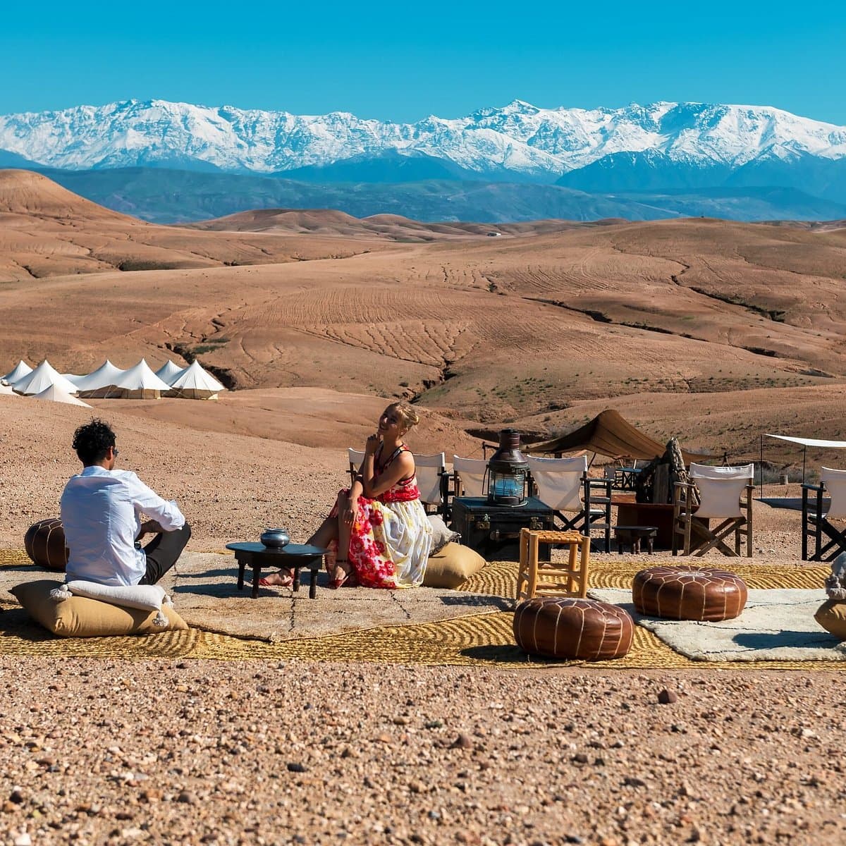 Couple relaxing at luxury desert camp with Atlas views